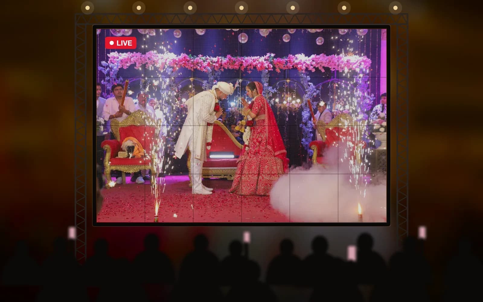 Guests watching the varmala live on a large LED wall at a night wedding
